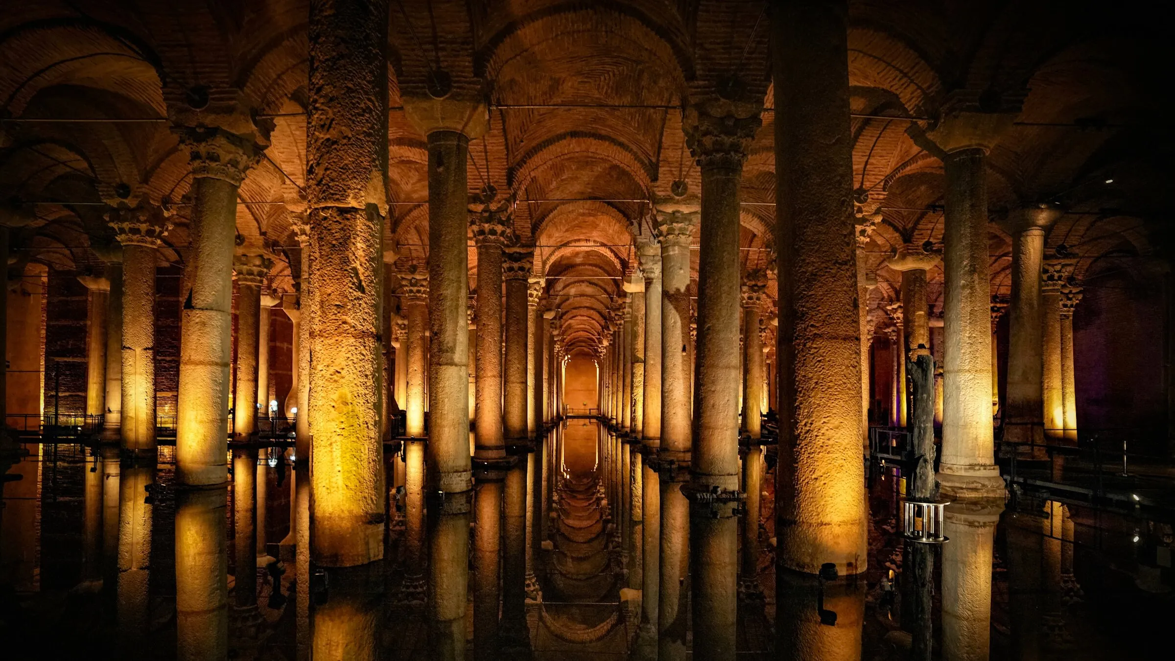 Rows of lit marble columns in the Basilica Cistern reflected in the water below